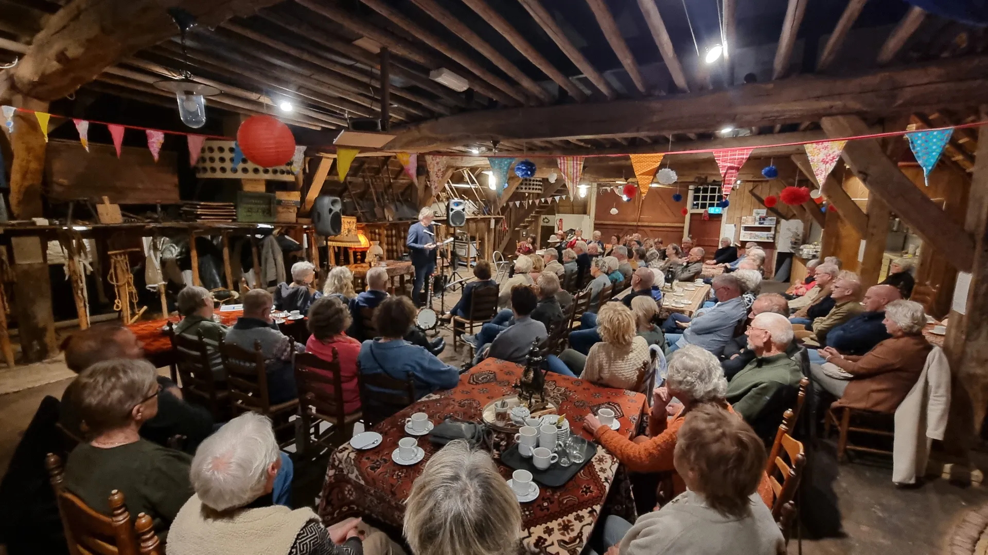 Sfeervol verlichte boerenschuur tijdens het festival